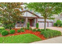 Charming two-story home features a 3 car garage, covered porch, and lush, mature landscaping at 5724 Shell Ridge Dr, Lithia, FL 33547