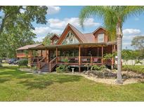 Inviting log-cabin-style home with a spacious covered porch and lush landscaping at 5817 Myrtle Ln, Tampa, FL 33625
