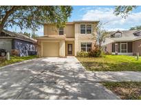 Inviting two-story home featuring a well-maintained lawn and a convenient one-car garage at 5839 Meadowpark Pl, Lithia, FL 33547