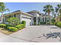 Charming single-story home featuring a well-manicured lawn, palm trees, and an attached two-car garage with spacious driveway at 6820 Muncaster Ct, Tampa, FL 33625