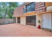 A large patio with sliding glass doors and a cozy balcony enhances the outdoor living space of this home at 714 1St Ct, Palm Harbor, FL 34684