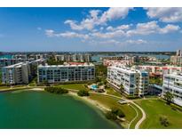 Beautiful aerial view of a waterfront condo community featuring lush landscaping and a swimming pool at 7872 Sailboat Key S Blvd # 301, South Pasadena, FL 33707