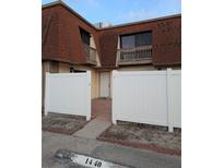 Townhouse with a white fence, red brick walk way and dark windows at 8114 Oak Trace Way # D, Tampa, FL 33634