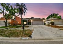 Charming single-Gathering home with a well-maintained lawn and a two-car garage, set against a dusk sky at 8736 Huntfield St, Tampa, FL 33635