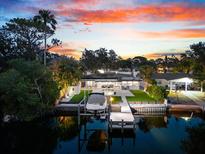 Waterfront home boasts private dock, boat lift, artificial turf and screened in lanai, all at sunset at 8848 Sunlit Cove Ne Dr, St Petersburg, FL 33702