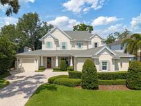 Elegant two-story home with a manicured lawn, lush landscaping, and a paver driveway leading to a spacious two-car garage at 911 S Sterling Ave, Tampa, FL 33629