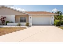 Charming single-story home featuring a two-car garage and well-maintained front yard at 106 Silverbell Ct, Sun City Center, FL 33573
