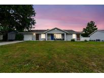 Charming single-story home with a well-manicured lawn, beautiful front door, and inviting curb appeal at 12106 Meadow Ln, San Antonio, FL 33576