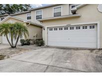 Townhouse features a two-car garage and well-maintained landscaping at 14985 Alan Ct, Largo, FL 33771