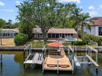 Waterfront home featuring a private dock with boat lifts and a refreshing pool at 150 Carlyle Dr, Palm Harbor, FL 34683