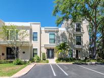 Modern townhome exterior with large windows, a well manicured lawn, palm tree, and on-site parking at 2807 W Hawthorne Rd # 11, Tampa, FL 33611