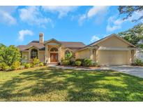 Charming single-story home with a well-manicured lawn and beautifully landscaped garden beds at 3908 Lithia Ridge Blvd, Valrico, FL 33596