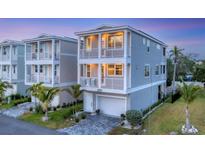 Beautiful two-story home featuring dual balconies, well-kept landscaping, and a paved driveway leading to a garage at 4357 Marina View Way, Cortez, FL 34215