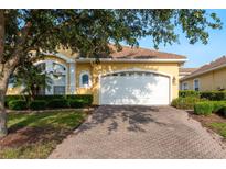 Charming yellow home with a brick driveway, well-kept lawn and beautiful landscaping at 4605 Casswell Dr, New Port Richey, FL 34652