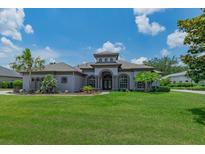 Stunning single-story home with arched windows, lush landscaping, and a well-manicured front lawn at 5507 Keeler Oak St, Lithia, FL 33547