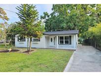 Charming home featuring a well-maintained front yard, fresh exterior paint and updated windows with decorative shutters at 10006 Memorial Hwy, Tampa, FL 33615
