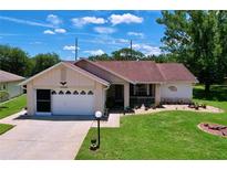 Charming single-story home featuring a well-manicured lawn and attached garage at 10520 Tapestry Dr, Port Richey, FL 34668