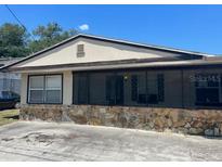 Quaint single-story home with a stone facade and screened-in porch for relaxed outdoor living at 1204 W Alsobrook St, Plant City, FL 33563