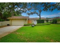 Charming single-story home with a lush front yard and mature shade trees at 13878 Oak Forest N Blvd, Seminole, FL 33776