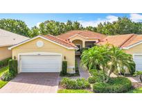 Charming single-story home with a red tile roof, two-car garage, and well-manicured landscaping at 16142 Amethyst Key Dr, Wimauma, FL 33598