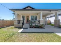 Charming home featuring a covered porch, manicured lawn, and welcoming curb appeal at 1813 Hillside Dr, Tampa, FL 33610