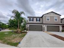 Beautiful townhome featuring neutral paint, well-maintained landscaping and an attached two-car garage at 23300 Willow Glen Way, Lutz, FL 33549