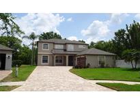 Beautiful two-story home with a brick paved driveway and lush landscaping at 3914 Roswell Pl, Land O Lakes, FL 34639