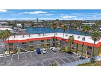 Waterfront condo building with palm trees, parking, and canal views offers relaxed coastal living at 4103 Gulf Blvd # 107, St Pete Beach, FL 33706
