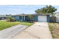 Inviting exterior of a blue home with a concrete driveway and manicured front yard at 4238 Glissade Dr, New Port Richey, FL 34652