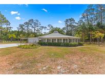 Charming home with a circular design, large windows, manicured hedges, and a well-maintained front yard at 495 Appaloosa Rd, Tarpon Springs, FL 34688