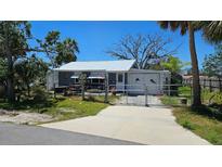 Charming single Gathering home featuring a well manicured lawn and a white metal roof at 6903 11Th Ave E, Palmetto, FL 34221