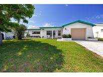 Charming single-story home with a well-maintained front lawn and attached garage at 7020 Sonata Dr, Port Richey, FL 34668