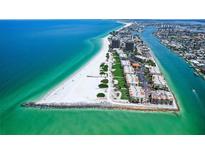 Stunning aerial view of beachfront condos with turquoise waters and white sand beach at 7564 Bayshore Dr # 302, Treasure Island, FL 33706