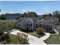 Charming single-Gathering home featuring a well-manicured lawn with vibrant pink flowers and a welcoming driveway at 116 S Arrawana Ave, Tampa, FL 33609