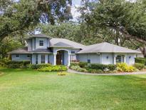 Stunning single-Gathering home featuring a lush lawn, mature trees and meticulous landscaping at 12002 Hope Ln, Tampa, FL 33618