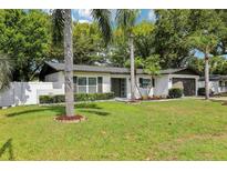 Charming home featuring a well-manicured lawn, fresh landscaping, and a white exterior with decorative shutters at 1332 Marjohn Ave, Clearwater, FL 33756