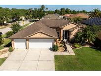 Charming single-Gathering home featuring a well-manicured lawn, a three-car garage, and beautiful landscaping at 1447 Stetson Dr, Wesley Chapel, FL 33543