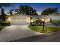 Charming single-story home featuring a well-manicured lawn, beautiful landscaping, and an attached two-car garage at twilight at 1530 Ingram Dr # 1530, Sun City Center, FL 33573