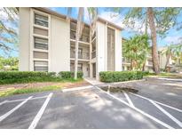 Well-maintained condo building with lush landscaping, mature trees, and convenient parking at 3038 Eastland Blvd # F102, Clearwater, FL 33761