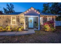 Charming single story home with a tidy landscaped yard and a decorative wreath on the front door at twilight at 3245 Freemont S Ter, St Petersburg, FL 33712