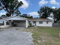 Cozy single-story home featuring a large front yard, a carport, and a classic front door at 37913 Wicklow Ave, Zephyrhills, FL 33541