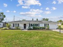 Charming single-story home featuring a well-manicured lawn and beautiful landscaping at 5812 52Nd N Ave, Kenneth City, FL 33709