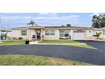 Charming single Gathering home with lush landscaping, spacious driveway, and attached one car garage at 6130 50Th N Ave, Kenneth City, FL 33709