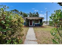 Charming blue one-story home with a red door and inviting front walkway at 6409 N 23Rd St, Tampa, FL 33610