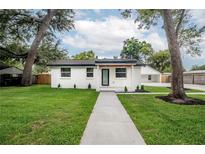 Charming home featuring a manicured lawn and fresh exterior paint at 6504 N 13Th St, Tampa, FL 33604