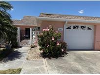 Charming home with a well-maintained lawn, walkway and a blooming hibiscus bush at 651 Boca Ciega Point S Blvd, St Petersburg, FL 33708