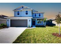 Charming two-story home boasts a manicured lawn, gray siding, and an attached two-car garage at 6807 162Nd Pl, Parrish, FL 34219