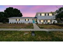 Charming two-story home with a well-manicured lawn and a striking, bright blue front door at 8413 Lopez Dr, Tampa, FL 33615