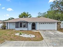 Charming single-story home featuring a screened porch, two-car garage, and well-maintained landscaping in a suburban neighborhood at 9107 Spring Hill Dr, Spring Hill, FL 34608