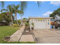 Charming single-story home with lush landscaping and a well-maintained front yard and a one car garage at 9616 56Th N St, Pinellas Park, FL 33782